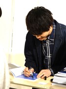 ファンの前でサインを書き込む多和田任益。