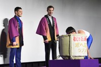 樽を運ぶひょっこりはんを見るラミ・マレック（左）とグウィリム・リー（中央）。