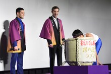 樽を運ぶひょっこりはんを見るラミ・マレック（左）とグウィリム・リー（中央）。