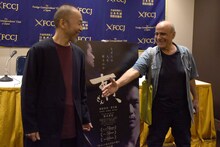 写真撮影に応じている塚本晋也（左）のもとへ近寄り、握手を求めるアミール・ナデリ（右）。