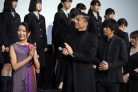 宝仙学園高等学校女子部の合唱隊に優しい目を向けるAKIRA（中央）。