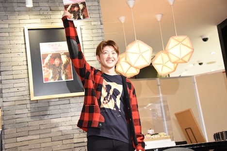 「獲ったどーみたい」と言いながら、写真集を掲げる佐野玲於。