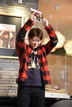 写真集を振ってアピールする佐野玲於。