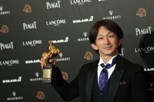 金馬奨のトロフィーを手にした谷垣健治。