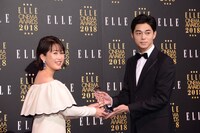 ELLE編集長の坂井佳奈子（左）からトロフィーを受け取る東出昌大（右）。