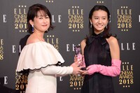 ELLE編集長の坂井佳奈子（左）からトロフィーを受け取るKoki,（右）。