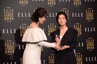 ELLE編集長の坂井佳奈子（左）からトロフィーを受け取る三島有紀子（右）。