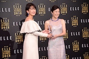 ELLE編集長の坂井佳奈子(左)からトロフィーを受け取る寺島しのぶ(右)。