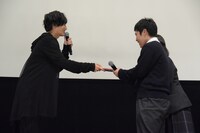 志尊淳（左）から「走れ！T校バスケット部」のフォトブックを受け取る高校1年生の2人組（右）。