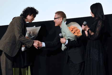 斉藤和義（左）と握手を交わす國村隼（中央）。