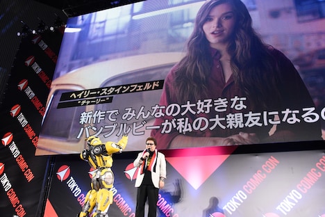 玄田哲章(右)と、映像の中のヘイリー・スタインフェルドに手を振るバンブルビー(左)。