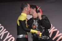 参加者の頬にキスするエズラ・ミラー（右）