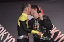 参加者の頬にキスするエズラ・ミラー（右）