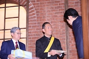 鈴木亮平(右)に特製マラソン足袋を渡す中村勘九郎(中央)。