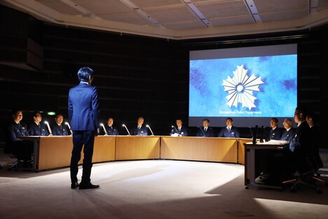 警視総監らの前に立つ壇浩輝役の千原ジュニア。