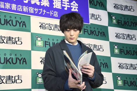 お気に入りの1枚を探す犬飼貴丈。