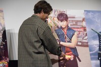 トッシーのバッジをペンライトで指し示す柳楽優弥。