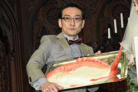 鯛の形をしたケーキを持つ吹越満。