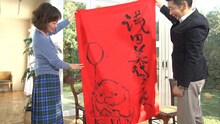 樹木希林が作成した手作りののれんを見せる浅田美代子（左）。