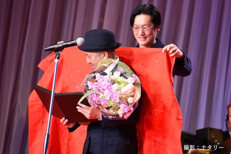 「止められるか、俺たちを」の旗を白石和彌（手前）にかける井浦新（奥）。