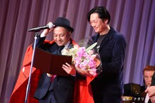 「止められるか、俺たちを」の旗を白石和彌（手前）にかける井浦新（奥）。