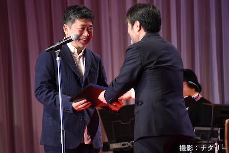 岸善幸（右）から表彰盾を受け取る是枝裕和（左）。