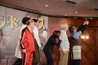 小日向文世（右）の携帯電話で記念撮影する登壇者たち。