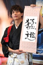 「猛進」としたためた書き初めを持つ中川大志。