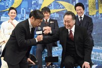 北大路欣也（手前右）からマイクを手渡され、恐縮する香川照之（手前左）。