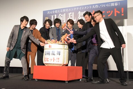 甘酒入りの酒樽で鏡開きを行う登壇者たち。