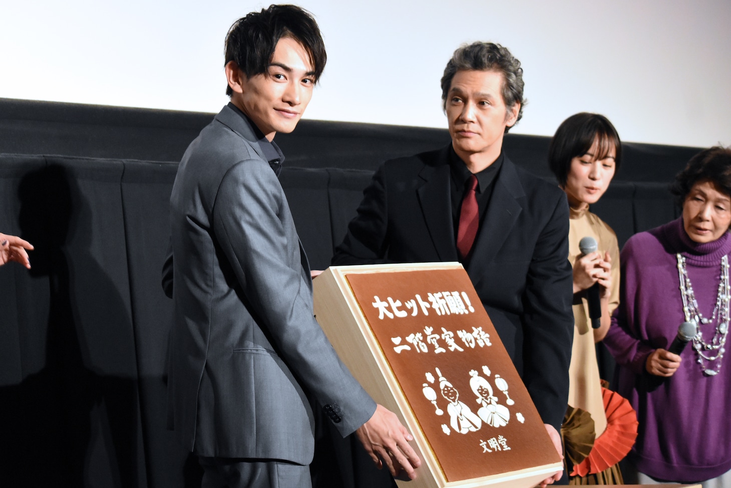 特製カステラを見せる加藤雅也（中央右）と町田啓太（左）。