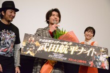 「平成仮面ライダーの申し子」と書かれたボードを見て、「やめてよ！」と照れる武田航平（中央）。