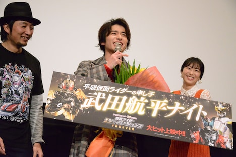 「平成仮面ライダーの申し子」と書かれたボードを見て、「やめてよ！」と照れる武田航平（中央）。