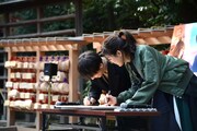 絵馬に願い事をしたためる高橋一生（奥）と川口春奈（手前）。