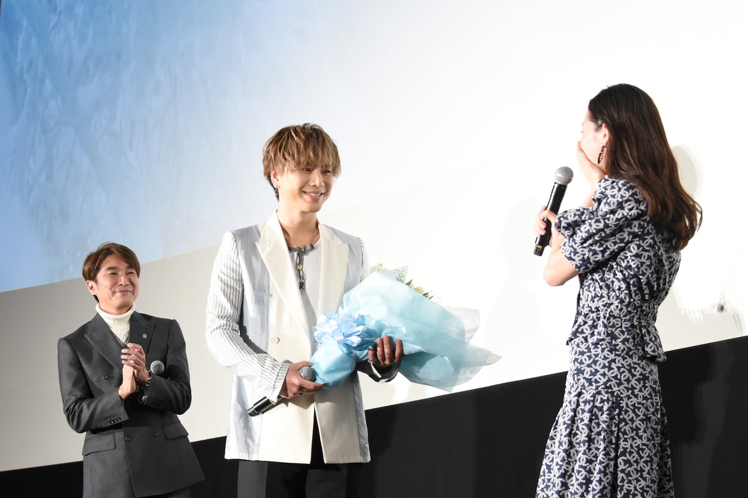 中条あやみ（右）に花束を渡す登坂広臣（中央）。