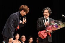 役所広司（右）から髪色をいじられる松坂桃李（左）。