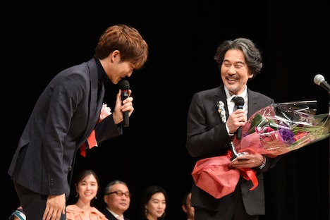 役所広司（右）から髪色をいじられる松坂桃李（左）。