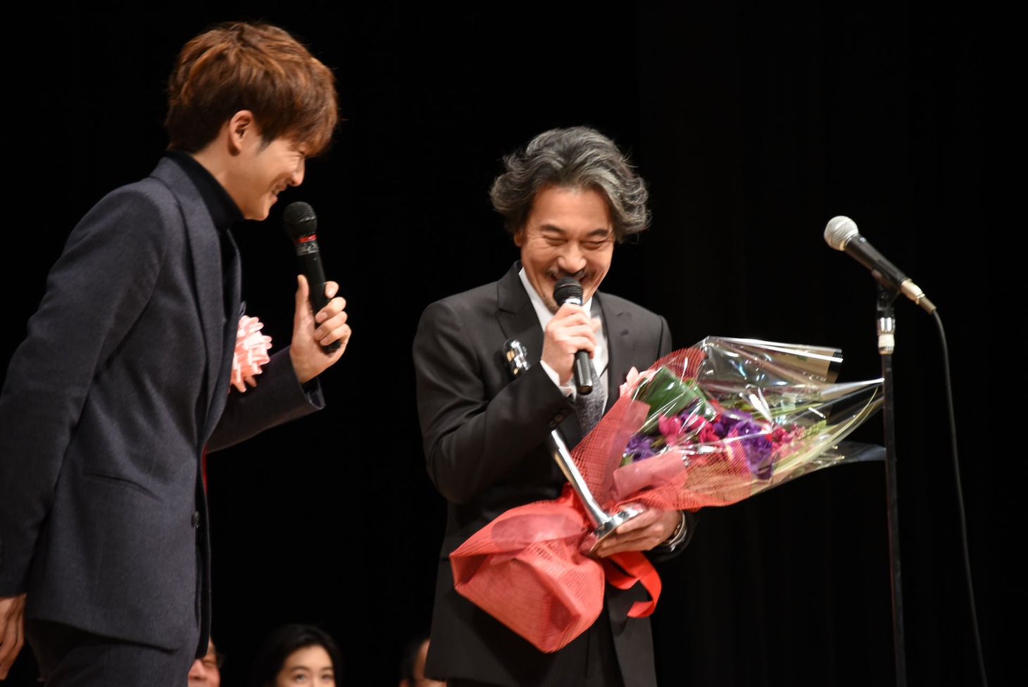 役所広司（右）から髪色をいじられる松坂桃李（左）。