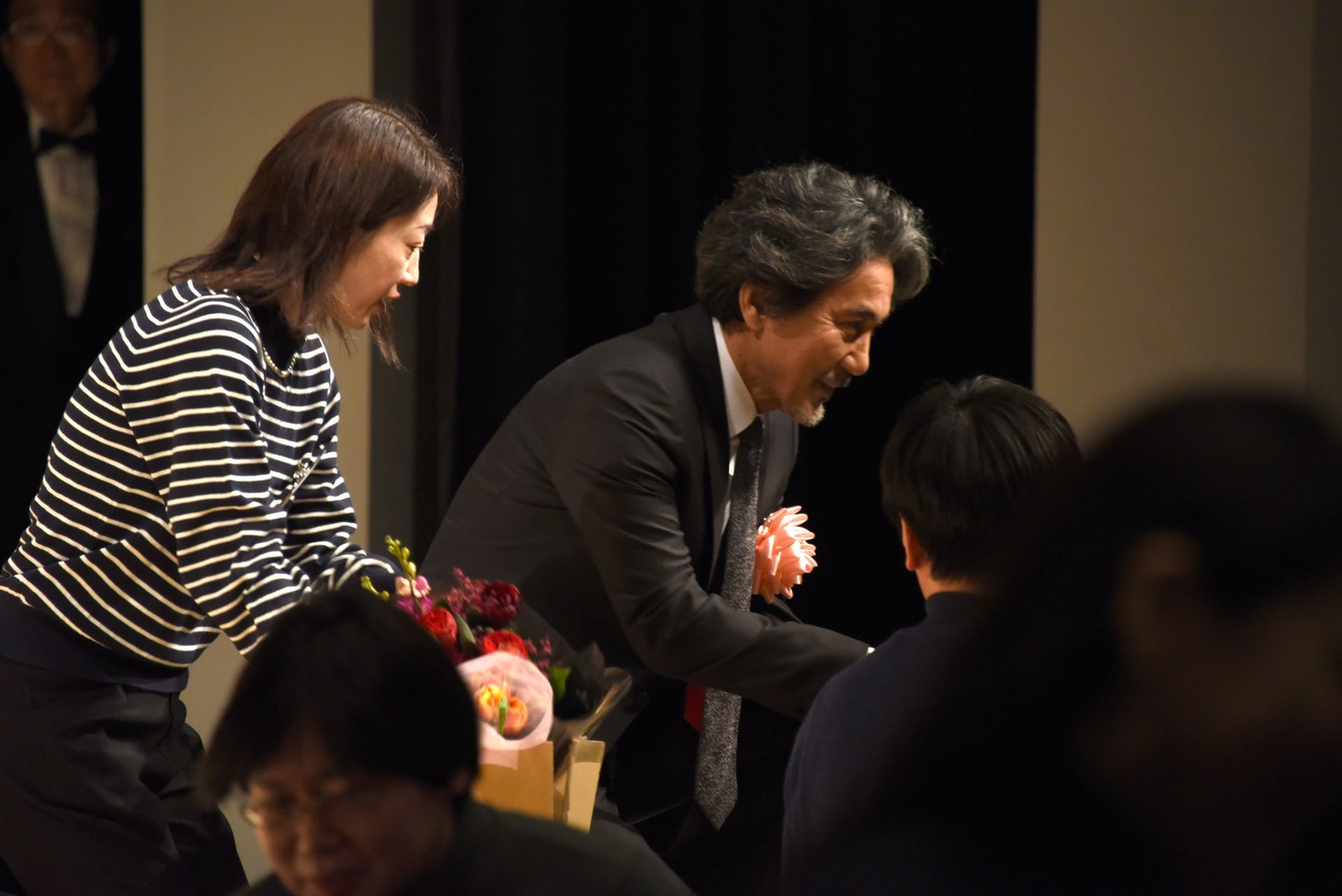ファンから花束を受け取る役所広司（中央）。