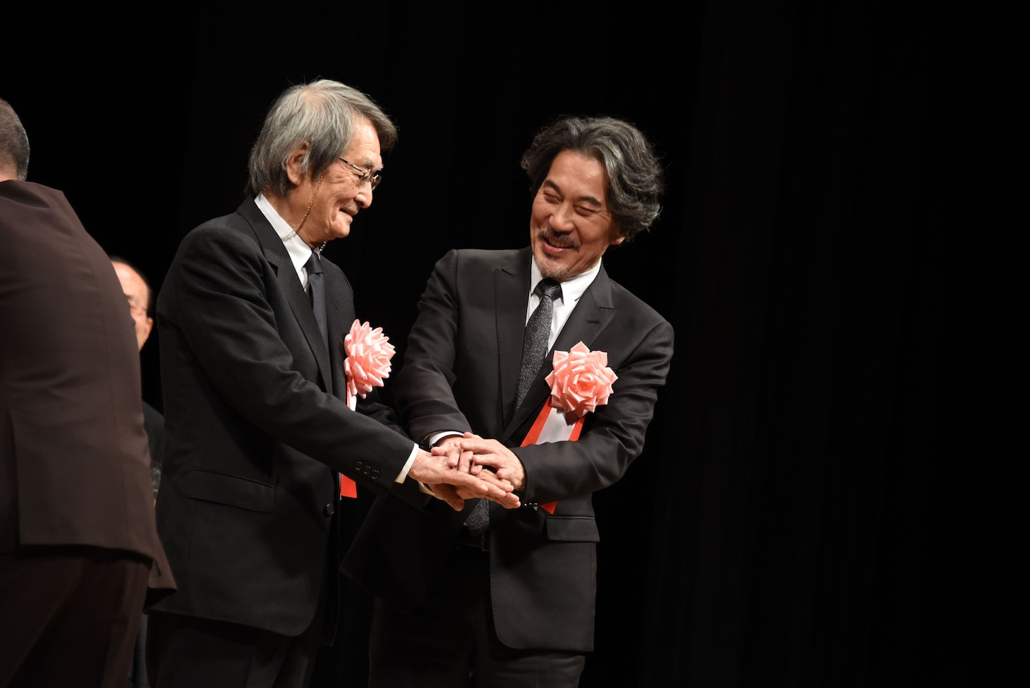 左から山崎努、役所広司。