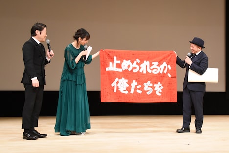 数多くのサインが入った「止められるか、俺たちを」の旗を見せる白石和彌（右）。