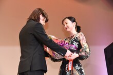 永野芽郁（右）に花束を贈る佐藤健（左）。