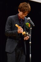 トロフィーの重みに思わず笑う松坂桃李。