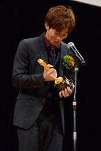 トロフィーの重みに思わず笑う松坂桃李。