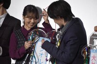 くす玉を割ったあと、中から出てきたテープを整える有村架純（左）と神木隆之介（右）。