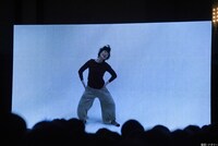 ビデオメッセージの中で、コマネチを披露するしゅはまはるみ。