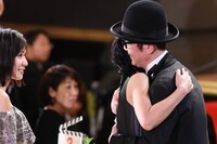 ハグを交わす安藤サクラ（中央）とリリー・フランキー（右）。それを笑顔で見つめる松岡茉優（左）。