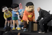 フォトセッションの準備を手伝おうとするジャイアン（右から2番目）と、「黒ずくめの人が来たよ！」となぜかスタッフを警戒するスネ夫（手前右から3番目）。