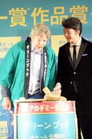 鏡割りをするピーター・ファレリー（左）、伊藤健太郎（右）。