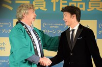 握手を交わすピーター・ファレリー（左）、伊藤健太郎（右）。